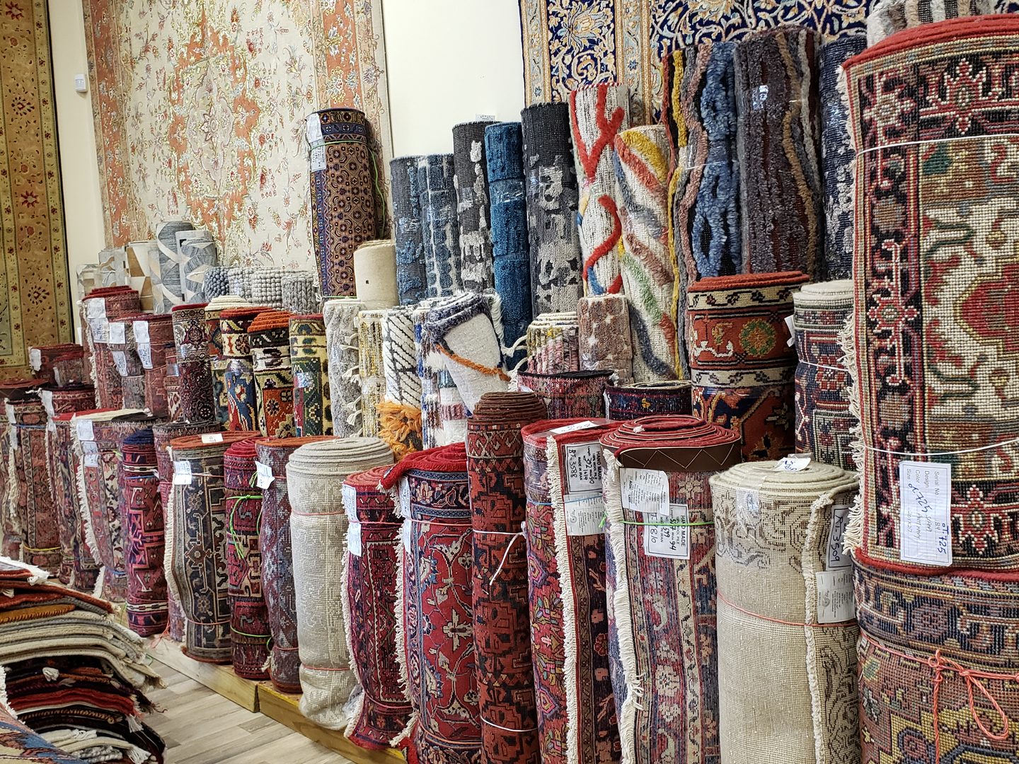 Rolled rugs stacked along the showroom wall