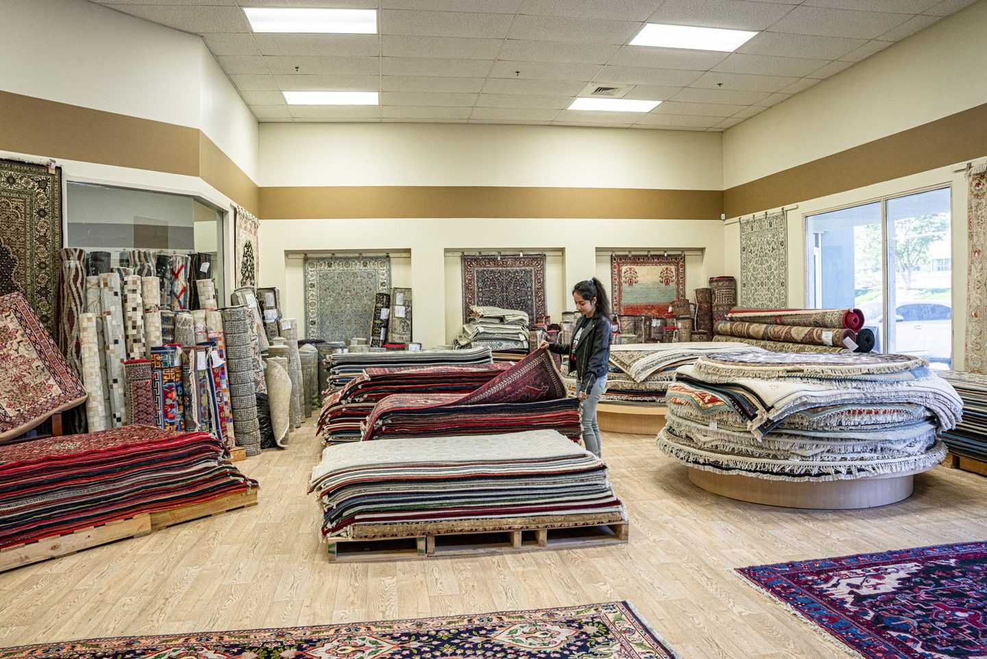 A customer looking through a stack of rugs in the showroom