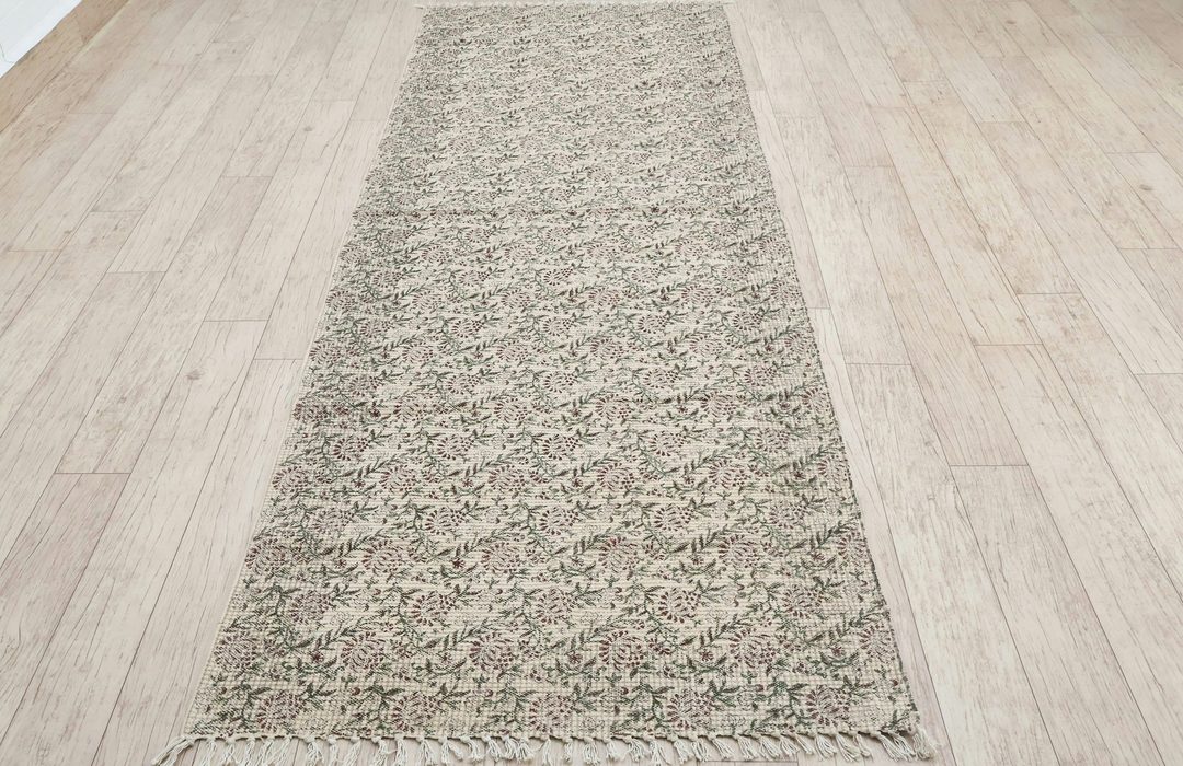 A kitchen with a runner rug along the counter